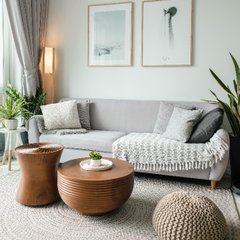 ljust vardagsrum med grå soffa och trä soffbord